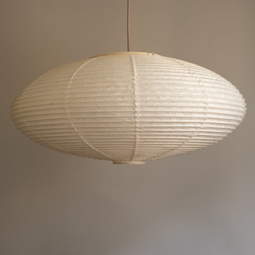 An elliptical-shaped Japanese paper lampshade from white Unryu paper, straight view, unlit.