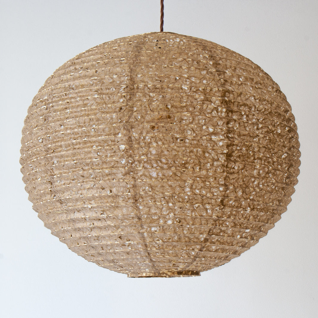 A 53cm diameter khaki coloured hemp paper lampshade in the asaraku style, with small holes left in the paper.