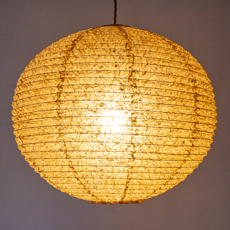 A large 53cm green/brown hemp washi paper lamp shade with small holes, hanging and casting a warm light.