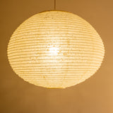 A large 71cm maru (round) paper lampshade, handmade from Japanese hemp washi paper in the asaraku style, where small holes are left in the paper, illuminated