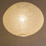 A large 71cm maru (round) paper lampshade, handmade from Japanese hemp washi paper in the asaraku style, where small holes are left in the paper, under view, illuminated