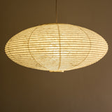 An elliptical-shaped Japanese paper lampshade from white Unryu paper, straight view, lit.