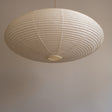 An elliptical-shaped Japanese paper lampshade from white Unryu paper, pictured from beneath, unlit.